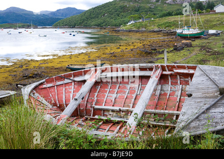 Una vecchia imbarcazione in legno spiaggiata a Badachro, a sud di Gairloch, Wester Ross, Highland, Scozia Foto Stock