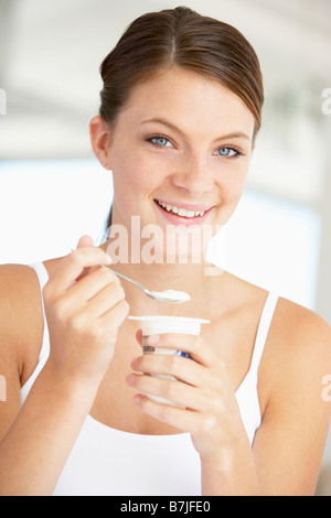Giovane donna di mangiare Yogurt Foto Stock