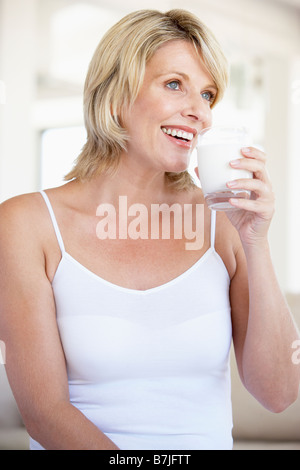 Metà donna adulta bere un bicchiere di latte Foto Stock