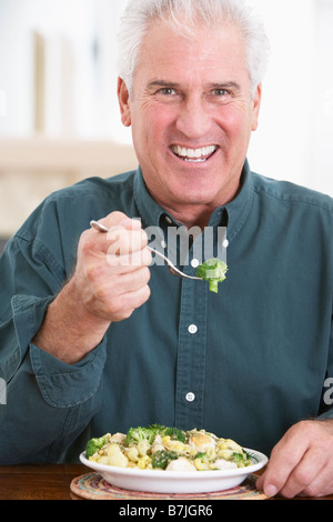 Uomo senior di mangiare un pasto sano Foto Stock