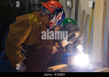 Un uomo incarica un altro uomo sulla saldatura Foto Stock