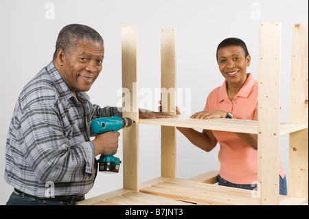 African American giovane facendo Home Improvement, il montaggio di una scaffalatura, Canada Columbia Britannica Foto Stock