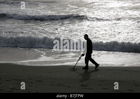 Uomo sulla spiaggia con il rivelatore di metalli Foto Stock