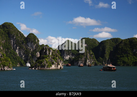 Barche nella baia di Halong Vietnam Foto Stock