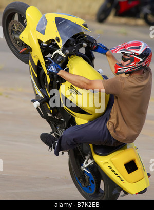 Stunt rider mono impennarsi in moto il ciclo di azione montante Foto Stock