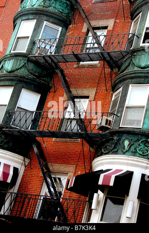 Frammento di una casa in mattoni rossi in Boston storico North End con balconi in ferro battuto e delle uscite di sicurezza Foto Stock