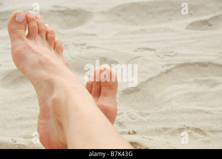 La donna in piedi su una spiaggia di sabbia Foto Stock