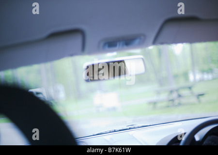 Volto di donna riflessa in uno specchio retrovisore Foto Stock