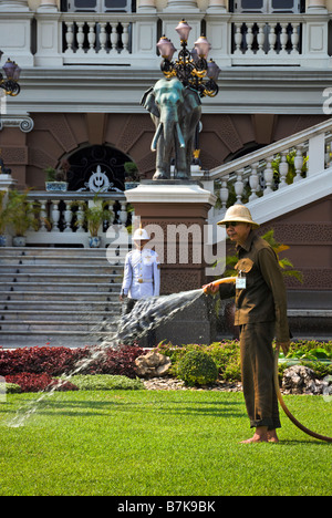 L uomo per irrigare il prato del Grand Palace Nel centro di Bangkok in Thailandia Foto Stock