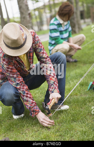 Gli uomini Ptching una tenda Foto Stock