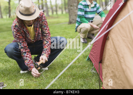 Gli uomini Ptching una tenda Foto Stock