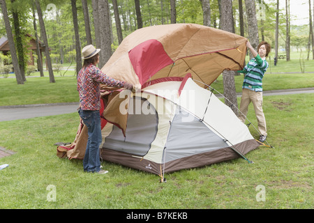 Gli uomini Ptching una tenda Foto Stock