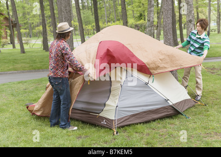 Gli uomini Ptching una tenda Foto Stock