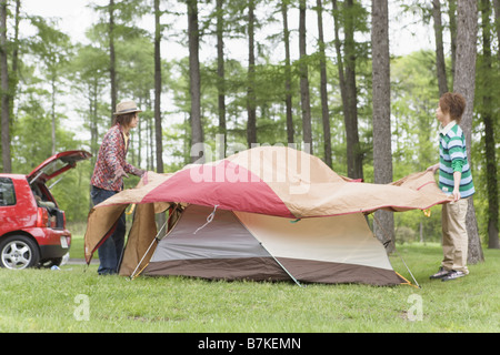 Gli uomini Ptching una tenda Foto Stock