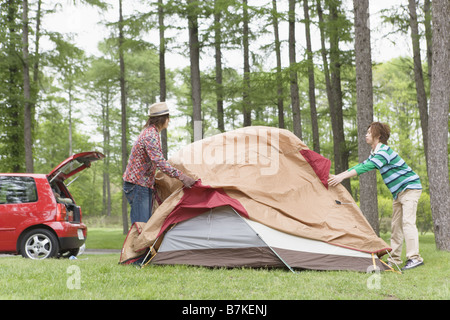 Gli uomini Ptching una tenda Foto Stock