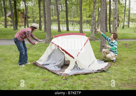 Gli uomini Ptching una tenda Foto Stock