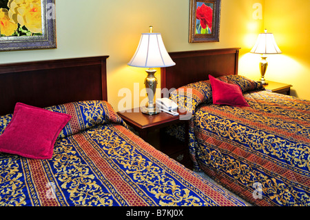 Camera da letto dell'hotel con un quadro e lampade sulla parete, comodini  con piante Foto stock - Alamy