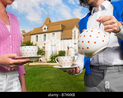 Bere il tè nella parte anteriore del paese home Foto Stock