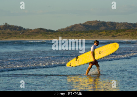 Surfer con tavola da surf su Playa Tamarindo, Costa Rica. Foto Stock