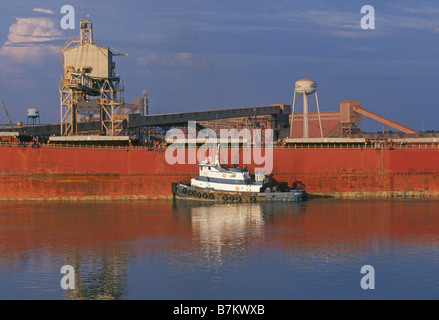 Un lavoro del fiume rimorchiatore legata a un grano grande barcone sul fiume Mississippi a nord di New Orleans Foto Stock