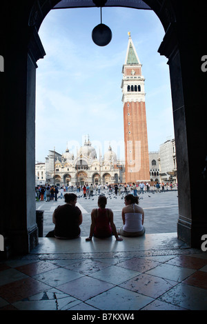 Turisti che si siedono sui gradini di Piazza San Marco, Venezia, Italia Foto Stock