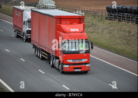 Assale tre Renault Premium carrello con red curtainsided tri rimorchio con assale onorevole Bathagte sulla autostrada M6 Foto Stock