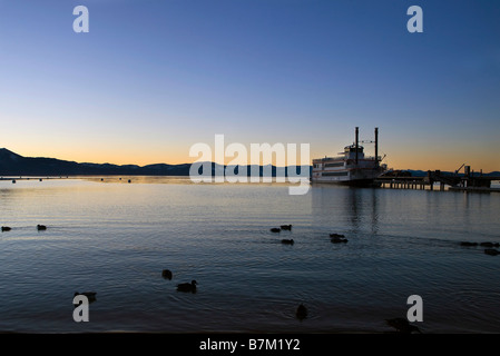Anatre nuotare nella parte anteriore del M S Dixie II inserito lungo il molo Zephyr Cove al tramonto Lake Tahoe Nevada Foto Stock