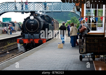 Attendere i passeggeri a bordo motore a vapore 69621 quali approcci Weybourne stazione sul Nord Stazione di Norfolk, Inghilterra, Regno Unito Foto Stock