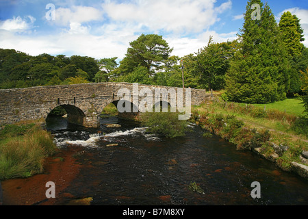 Un antico ponte in pietra tra Est Dart River a Postbridge, Parco Nazionale di Dartmoor Devon England Regno Unito Foto Stock