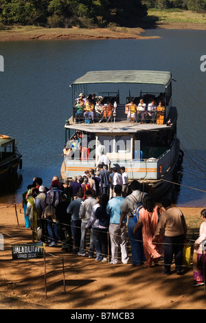 Persone di salire a bordo di una delle imbarcazioni turistiche che il velo del Periyar nel Lago del Periyar Wildlife Sanctuary in Kerala India Foto Stock