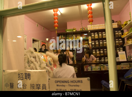 Un Leone danza avviene all interno di una natura e salute store in China town , Soho Londra Foto Stock