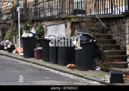 Domestico scomparti wheelie e sacchetti ammucchiati in attesa raccolta su strada Foto Stock