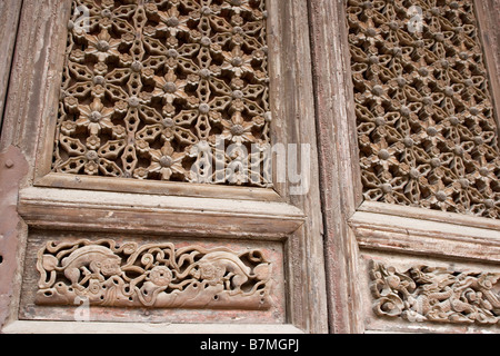 Sculture in legno su una porta a Chenghuang Miao Tao tempio in Xian in Cina. Foto Stock