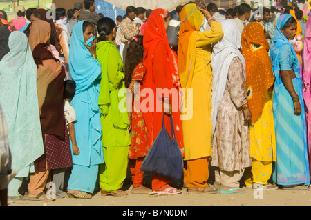 Una lunga coda di donne e ragazze vestiti nei loro vestiti migliori aspettando pazientemente che il cibo gratuito presso il festival di Mewar. Foto Stock