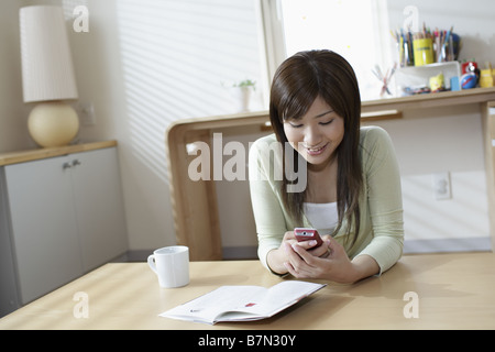 Donna che mantiene un Cell-Phone Foto Stock