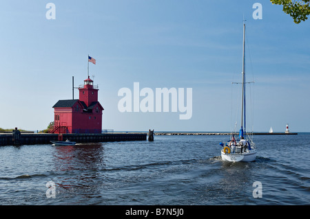 Barca a vela Motoring passato l'Holland Faro del porto sul Lago Michigan Holland Michigan Foto Stock
