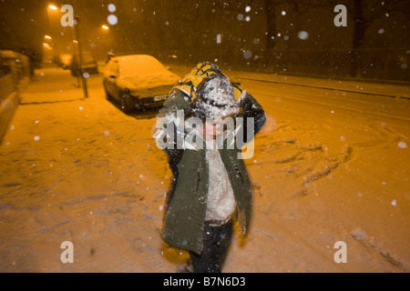 Un bambino gioca snowballs di notte durante una forte bufera di neve nel centro di Londra, un evento raro per un southern all interno della città Foto Stock