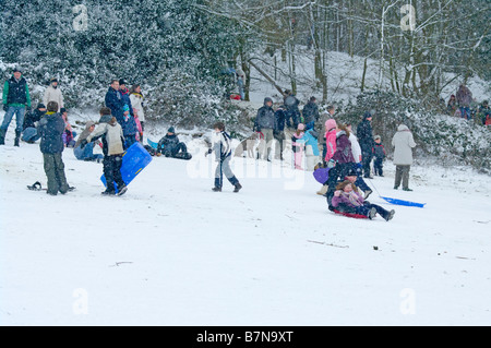 Persone a giocare nella neve in Reigate Priory Park Surrey UK Winter Foto Stock