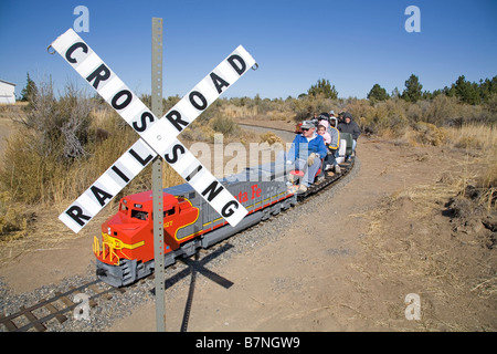 I visitatori di un piccolo museo della ferrovia in curva, Oregon, cavalcare un Santa Fe locomotore ferroviario intorno a una serie di piccole i binari della ferrovia Foto Stock