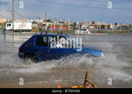 Car guida attraverso le acque di esondazione sulla strada, Javea, Alicnate Provincia, Comunidad Valenciana, Spagna Foto Stock