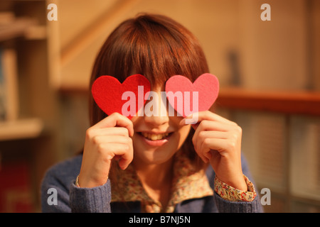 Donna che mantiene forme di cuore Foto Stock