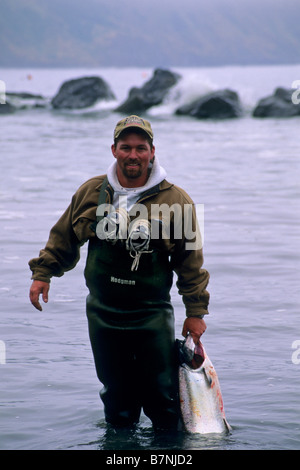 Pescatore in piedi in acqua holding salmoni catturati durante la pesca Shelter Cove Humboldt County in California Foto Stock