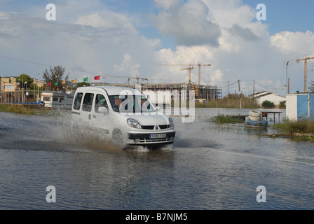 Van guidando attraverso l'acqua di allagamento sulla strada, Javea, Alicnate Provincia, Comunidad Valenciana, Spagna Foto Stock