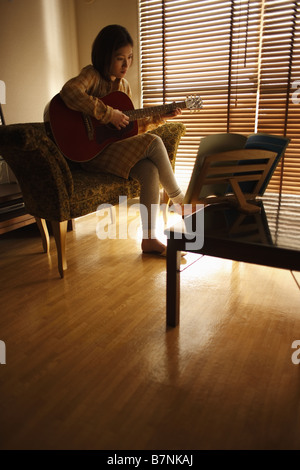 Una donna a suonare la chitarra Foto Stock