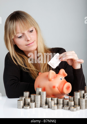 Giovane donna con un piggybank Foto Stock