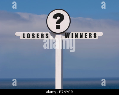 Cartello bianco con i cartelli dei vincitori e dei perdenti in direzioni opposte con un punto interrogativo al centro, visto contro il cielo blu. Foto Stock