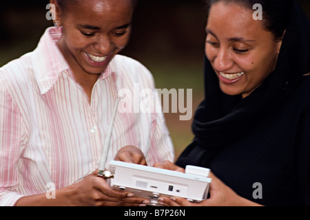 Due donne che fanno un telefono wireless chiamata in un parco Nairobi Kenya Foto Stock