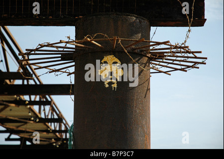 Un volto che rappresenta Gesù Cristo verniciato a spruzzo sul rusty resti del molo Ovest di Brighton, Sussex, Regno Unito. Foto Stock