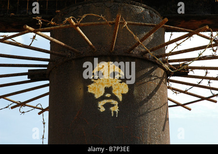 Un volto che rappresenta Gesù Cristo verniciato a spruzzo sul rusty resti del molo Ovest di Brighton, Sussex, Regno Unito. Foto Stock