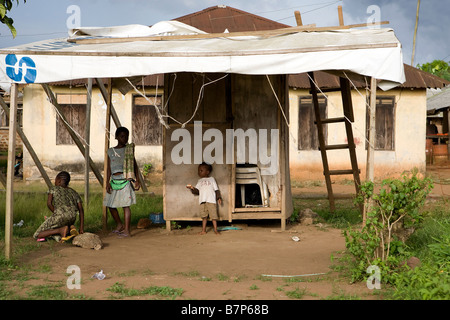 3 nigeriana per i bambini a giocare all'ombra del coperchio improvvisati davanti alla loro casa che ha intavolato windows Foto Stock